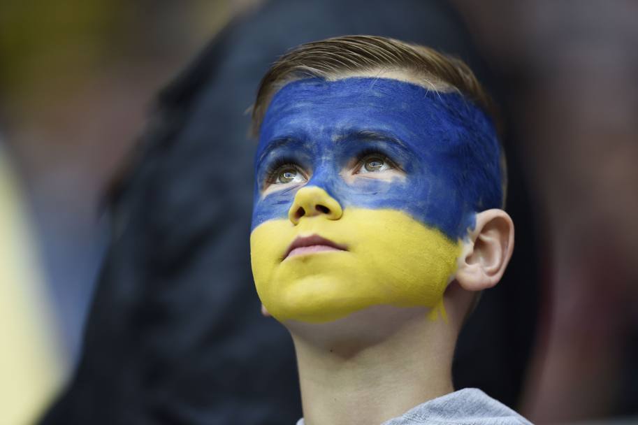 Un bambino dal volto dipinto con i colori della bandiera ucraina. Afp